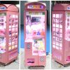 Phone booth style claw machine with colorful stuffed toys inside, attracting players with its vintage design