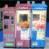 Phone booth style claw machine with colorful stuffed toys inside, attracting players with its vintage design