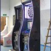 Coin-operated dart game machine with two screens for multiplayer competitions.