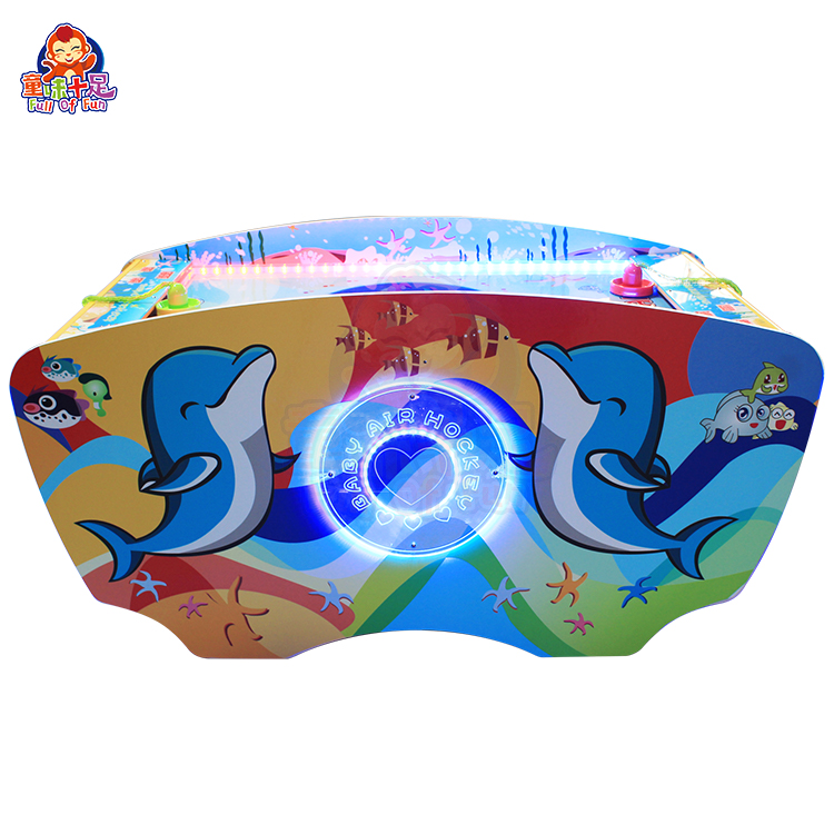 Children playing on a coin-operated dual-player air hockey machine.