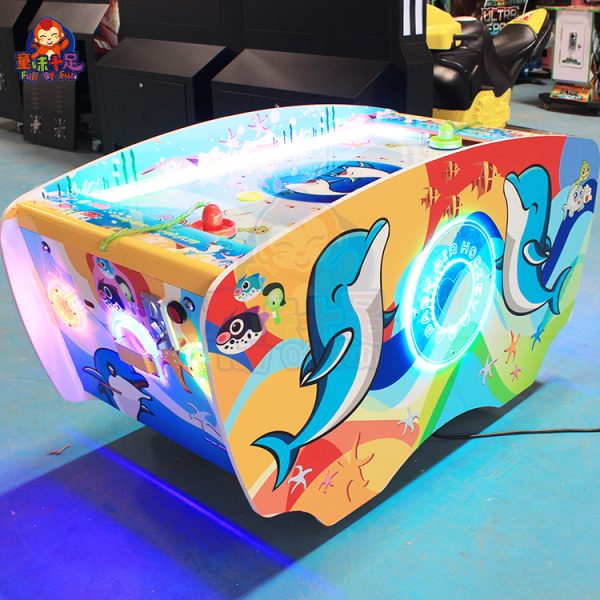 Children playing on a coin-operated dual-player air hockey machine.